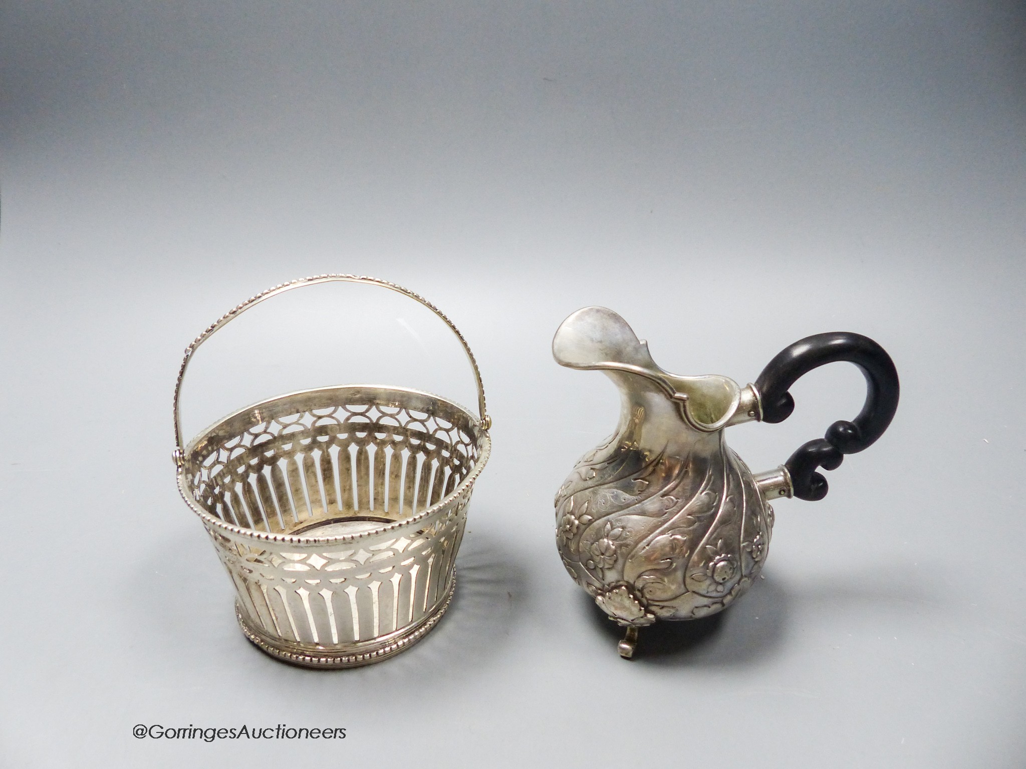 A 19th century Dutch white metal sugar basket (no liner), height 6cm and a Portuguese white metal cream jug, gross 7.5oz.